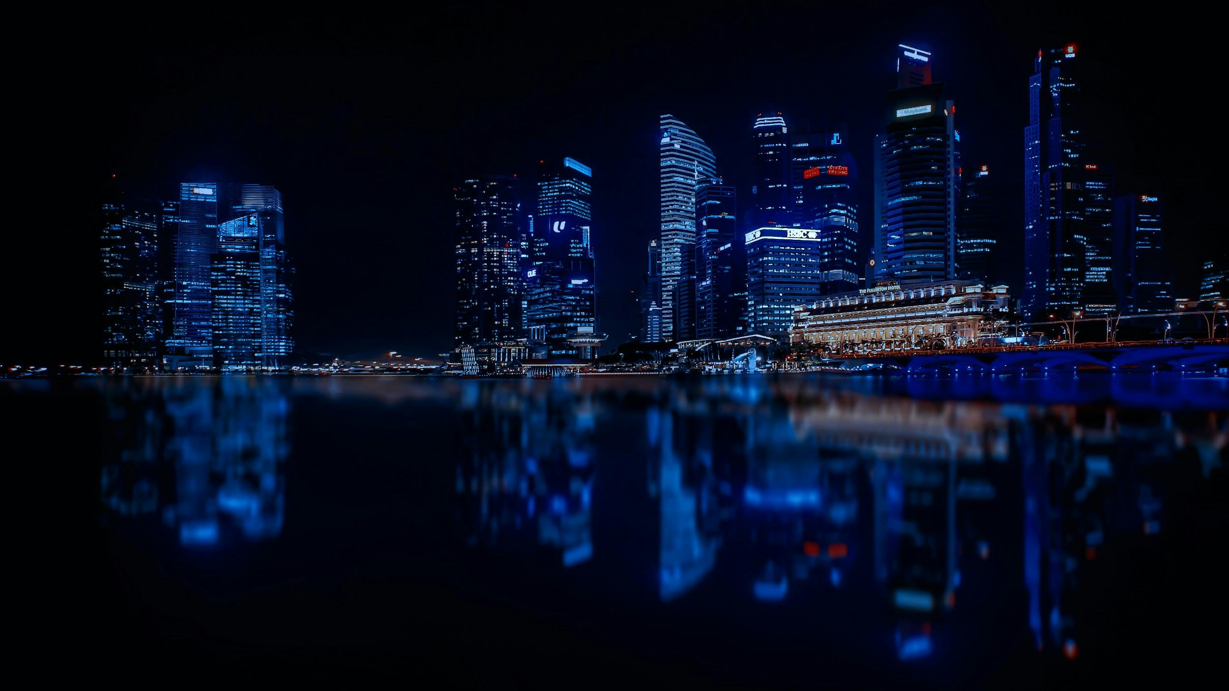 illuminated cityscape against blue sky at night