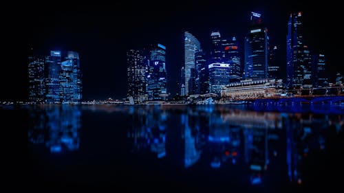 бесплатная Освещенный городской пейзаж против голубого неба ночью Стоковое фото