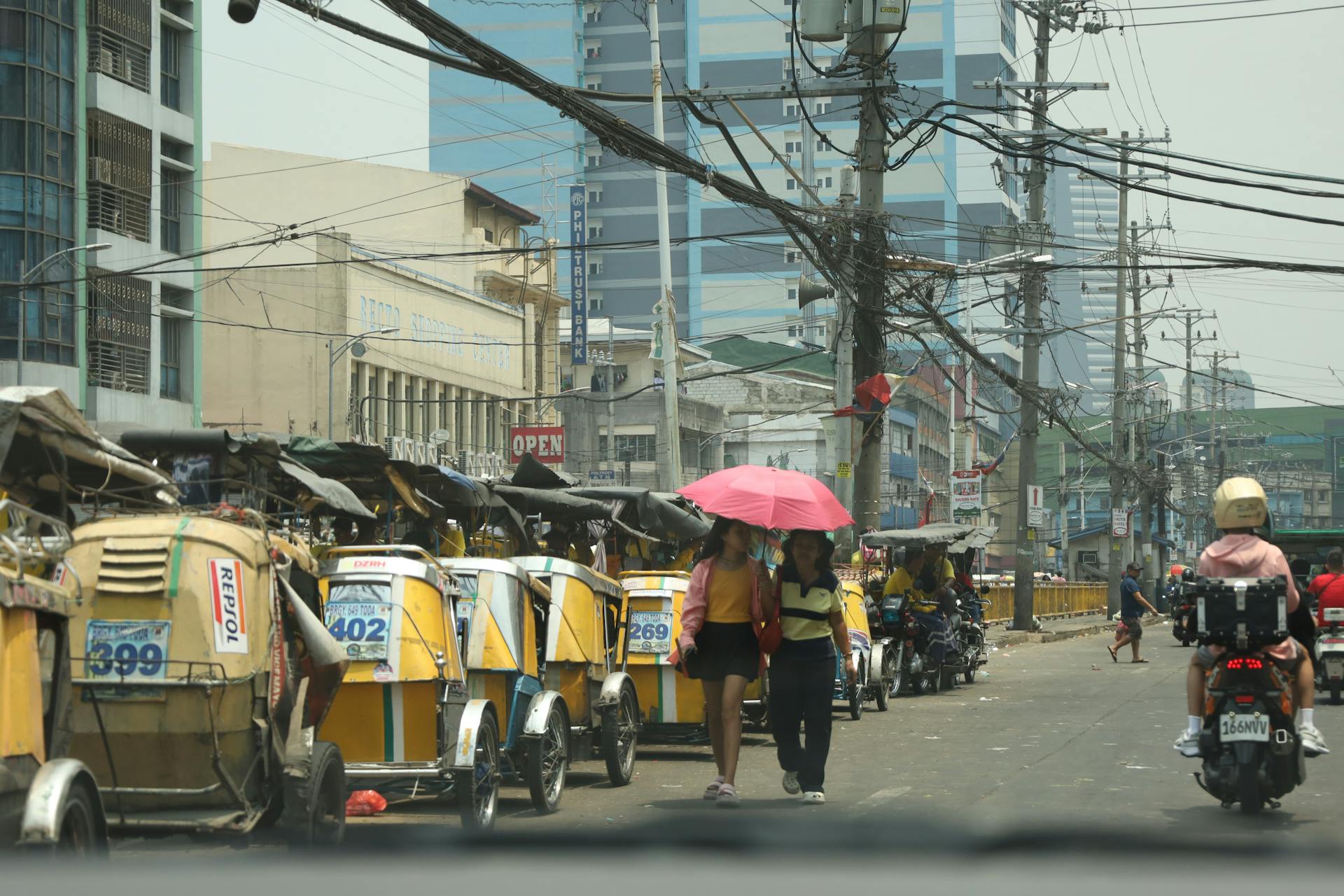 Vibrant Manila street scene featuring jeepneys, motorcycles, and pedestrians under a sunny sky.