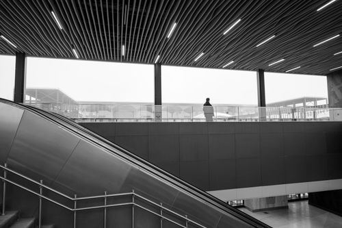 Free A single figure silhouetted against modern architecture in Istanbul. Urban landscape and solitude captured. Stock Photo