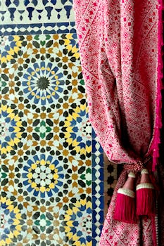 Colorful Moroccan mosaic tiles with traditional red textile curtain in Fès, Maroc.