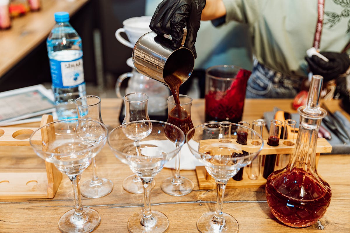 A mixologist pouring cocktails into elegant glasses at an event bar