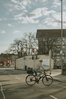 A cyclist crossing a street in Bad Hersfeld, Germany, highlighting eco-friendly urban lifestyle.