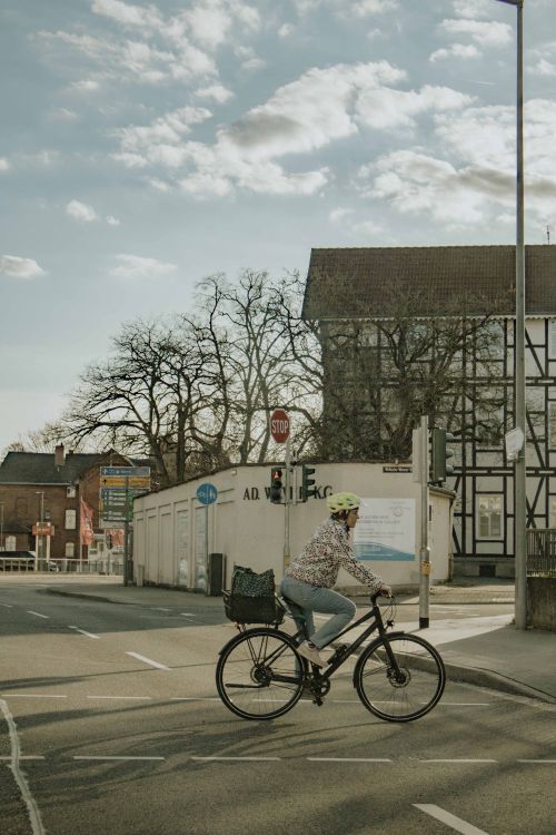 Free A cyclist crossing a street in Bad Hersfeld, Germany, highlighting eco-friendly urban lifestyle. Stock Photo