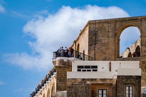 Free Capture of Valletta's Upper Barrakka Gardens with historic arches and fortifications against a clear blue sky. Stock Photo