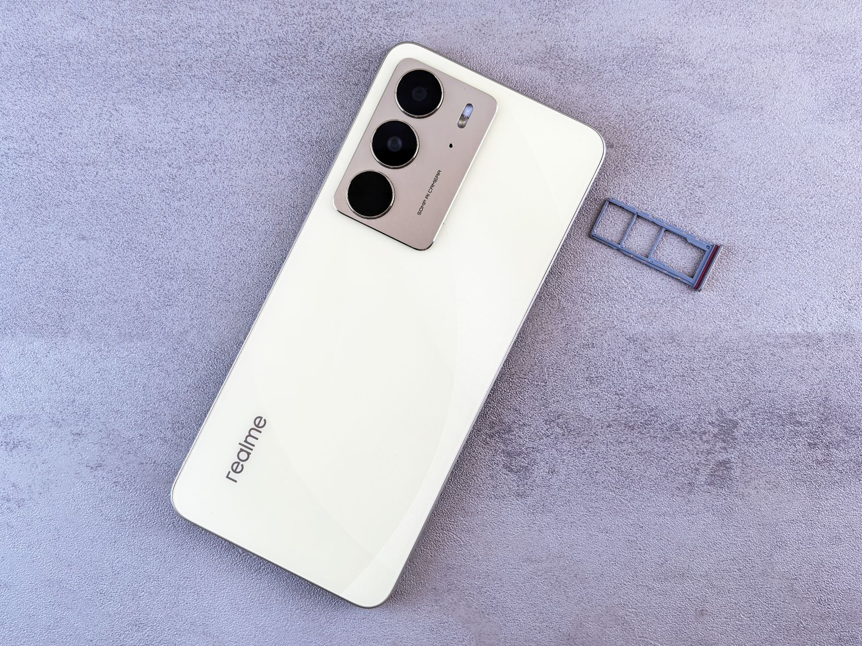 How to Fix a Phone Stuck on Searching for Network (Android and iPhone) Elegant white smartphone on a grey surface next to a SIM card tray, showcasing modern design