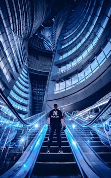 在未来派摩天大楼的自动扶梯场景中，一个人站立着，捕捉现代城市设计的精髓