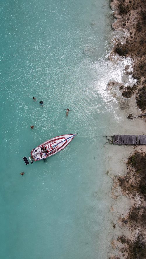 Free Stunning aerial view of a boat and swimmers in the clear turquoise waters of Quintana Roo, Mexico. Stock Photo