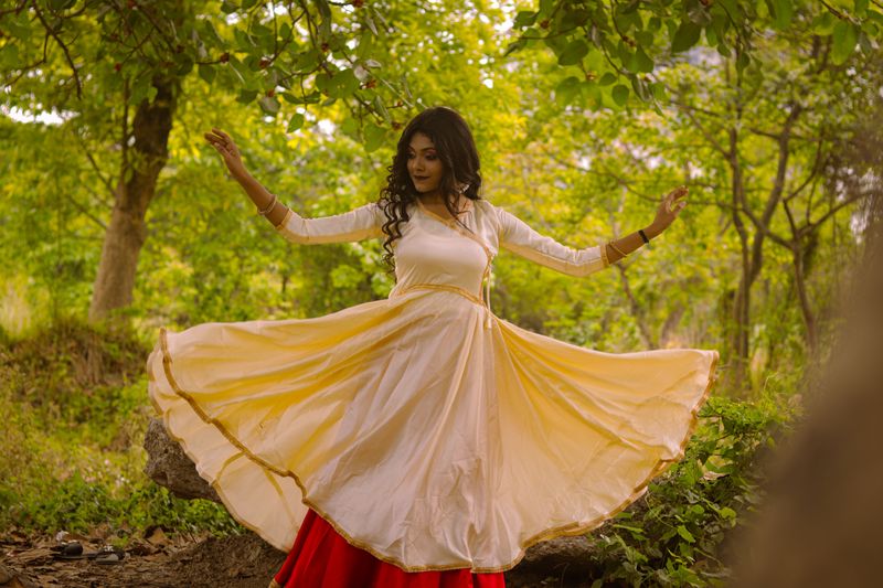 A young Indian dancer performing expressive contemporary movement outdoors