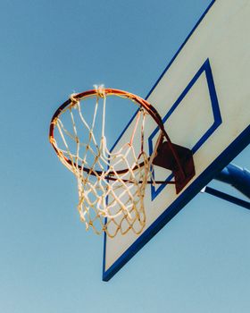 A close-up shot of a basketball hoop on a sunny day, symbolizing outdoor sports.