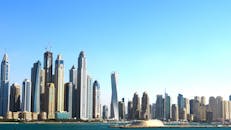 迪拜高耸的摩天大楼映衬着充满活力的蓝天和海滨，构成一幅全景