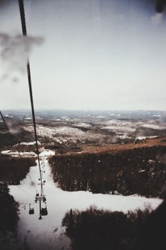 Aerial view of snow-covered mountains and ski lift during winter.