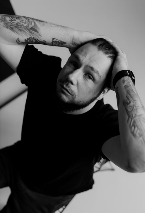Free Thoughtful black and white portrait of a tattooed man in a relaxed pose. Stock Photo