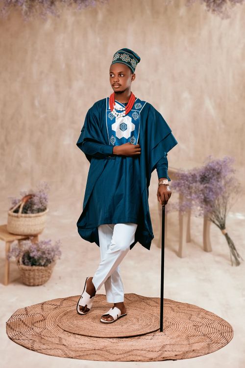 Free Man in traditional African clothing with intricate design, holding a cane. Stock Photo