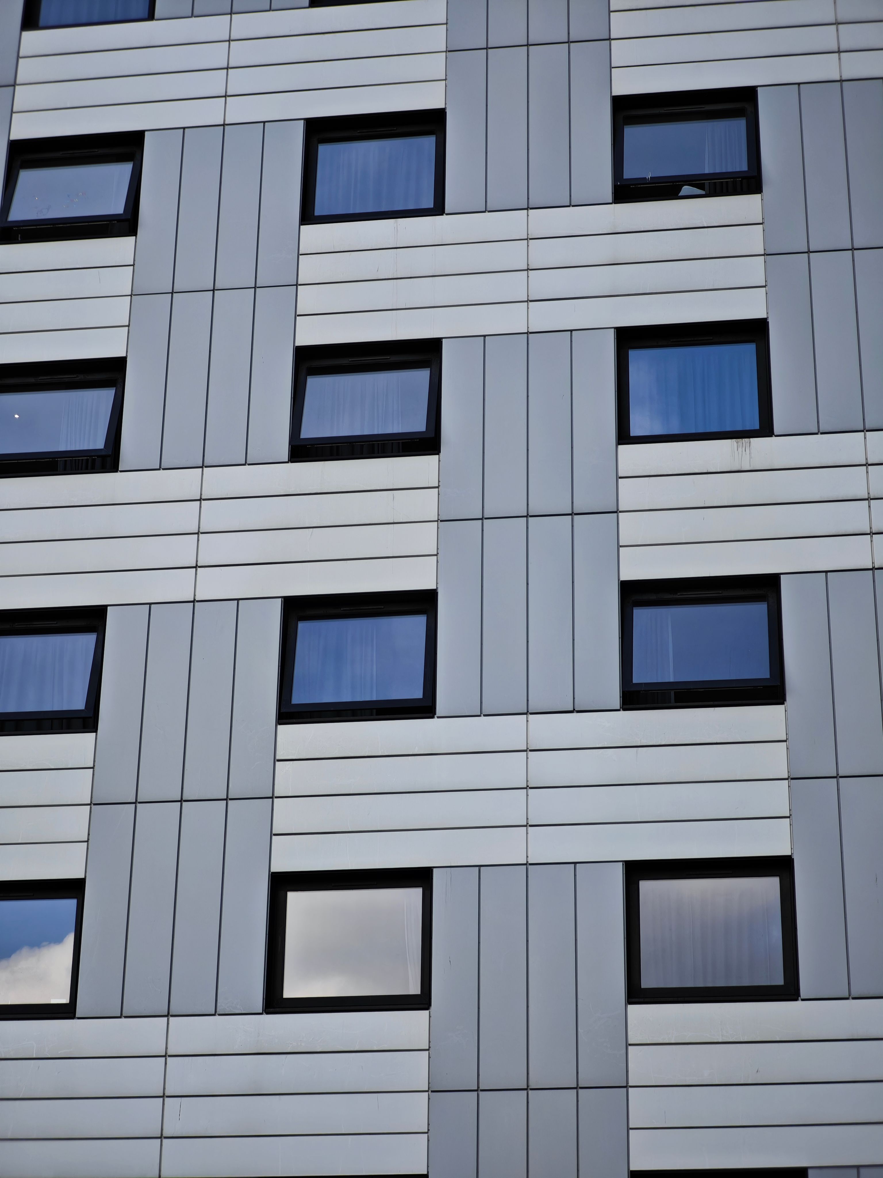 Detailed view of a modern building facade with geometric window patterns.