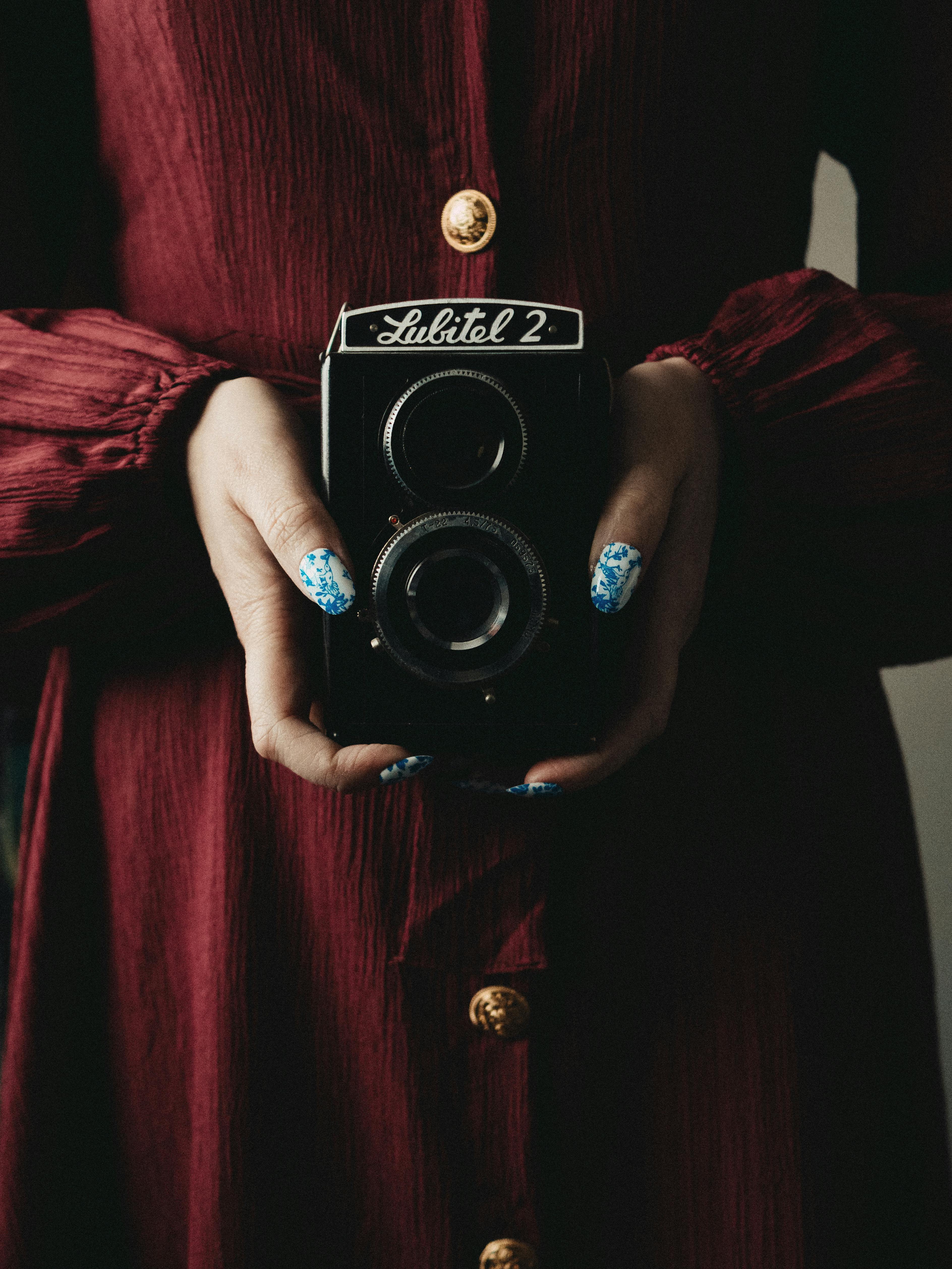 Close-up of a woman holding a vintage Lubitel camera, creating a retro aesthetic.