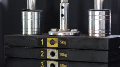 Detailed view of a weight stack on a gym machine, showing various weight levels in kilograms.