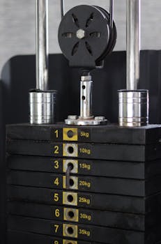 Detailed view of a weight stack on a gym machine, showing various weight levels in kilograms.