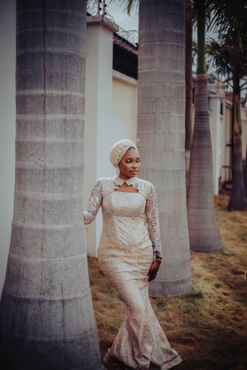 Free Woman in elegant traditional dress standing by palm trees outdoors. Stock Photo