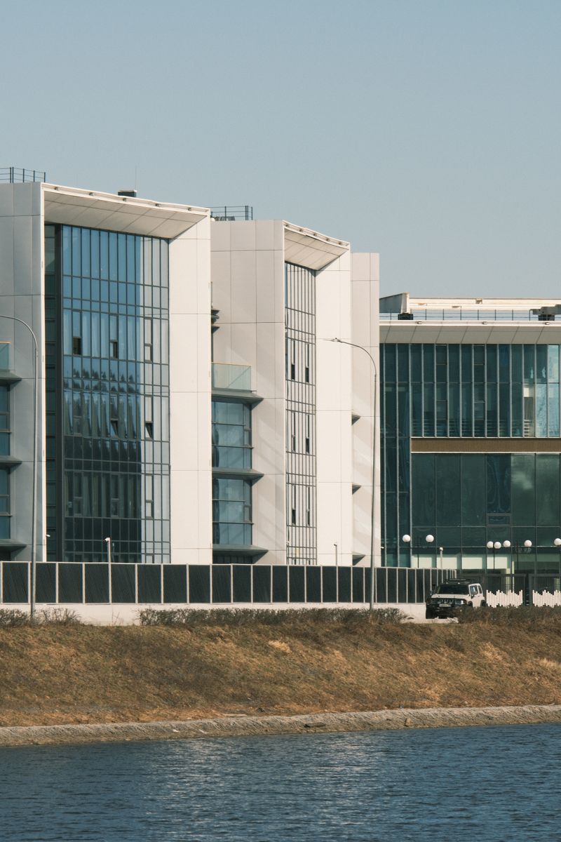 Contemporary architecture with glass facades overlooking a tranquil river.