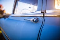 一辆复古蓝色汽车上，镀铬手柄的详细特写，突出了经典设计