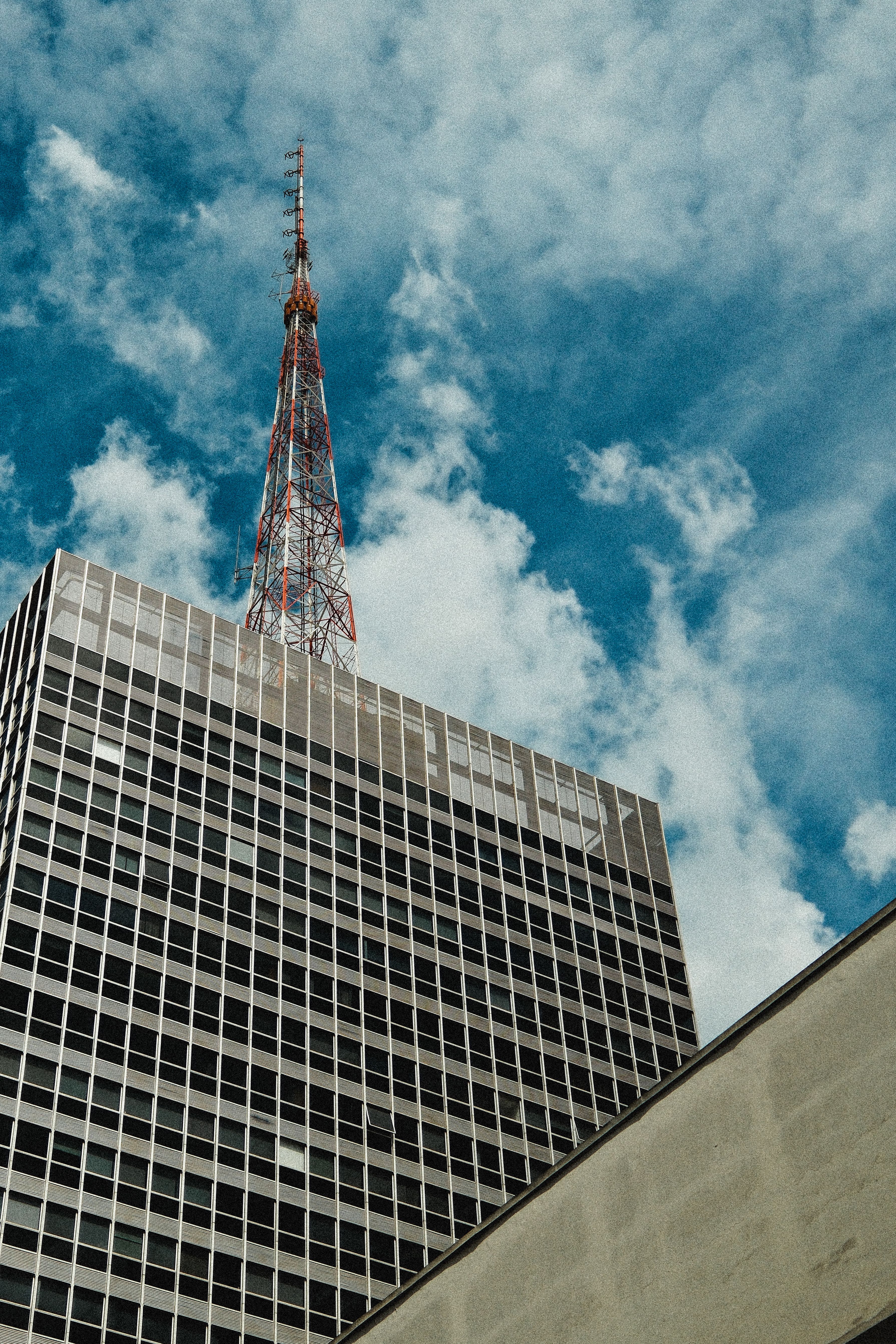 Modern Skyscraper with Antenna Against Blue Sky · Free Stock Photo