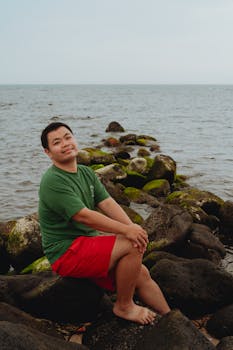 A person enjoying a peaceful moment by the rocky seaside in Bình Thuận, Vietnam.