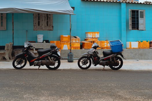 Two parked motorcycles against a blue-tiled wall in Bình Thuận, showcasing local life.