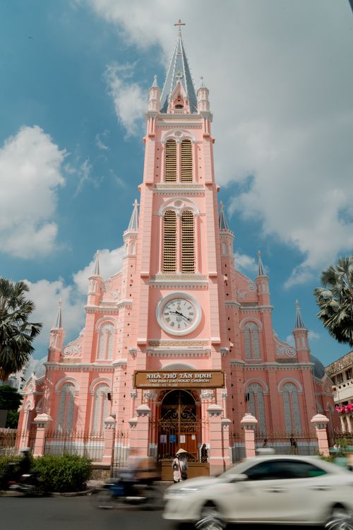 Free Stunning view of the Pink Tan Dinh Church under a vibrant blue sky with motion around it. Stock Photo