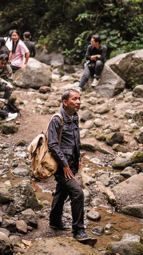 Free A group explores a rocky path in a forested area of West Java, Indonesia. Stock Photo