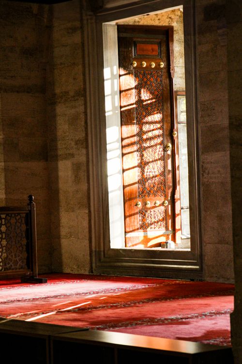 Free Sunlight casting shadows through an ornate mosque door with rich textures. Stock Photo