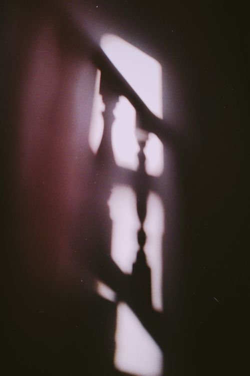 Free Artistic abstract shadow of railing cast on wall, creating a mysterious mood. Stock Photo