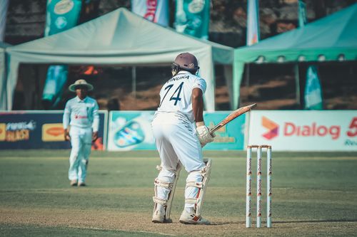 Free Cricketer in uniform ready to bat on a sunny day. Outdoor sports scene. Stock Photo