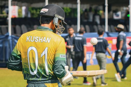 Free Cricket player in action with ball and bat, ready for the match outdoors on a sunny day. Stock Photo