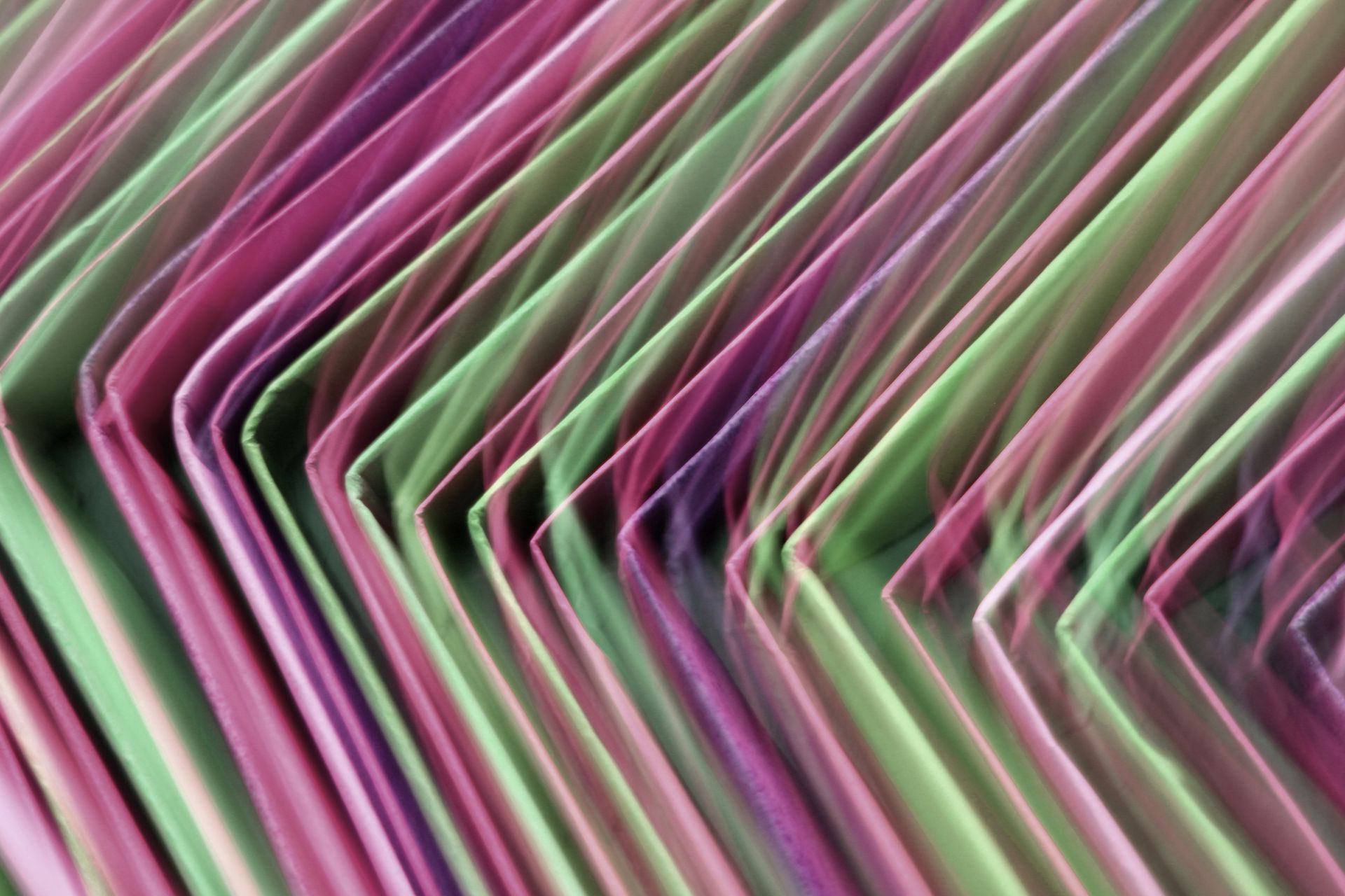 A vibrant abstract image of pink and green folders with motion blur, creating an artistic effect.