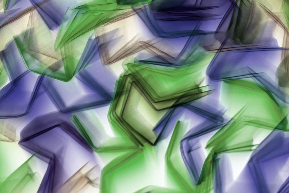 Dynamic abstract image featuring overlapping green and blue geometric shapes creating a vivid pattern.
