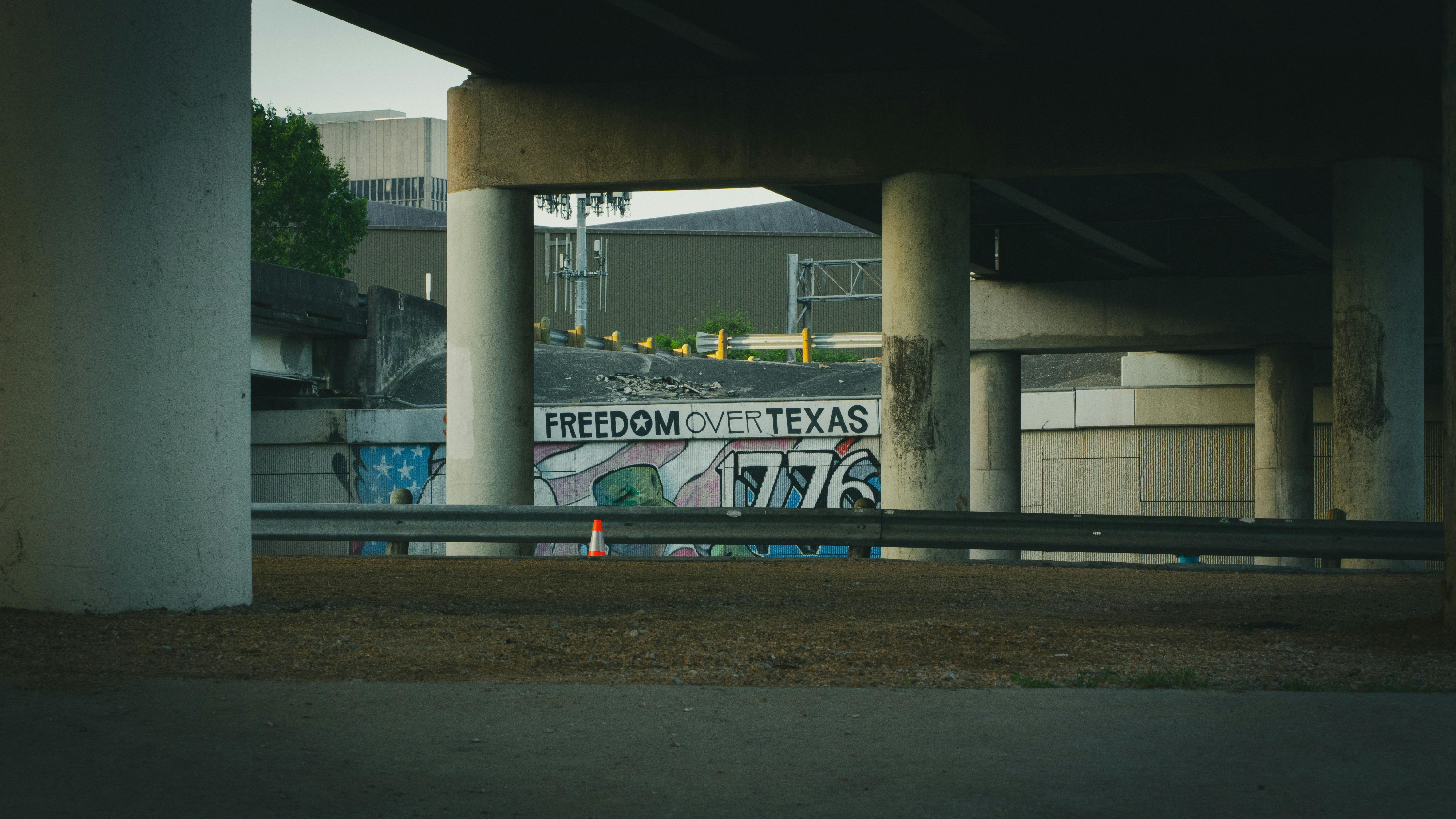 ฟรี งานศิลปะกราฟฟิตี้ที่มีข้อความ 'Freedom Over Texas' ใต้สะพานคอนกรีตในเมืองฮูสตัน คลังภาพถ่าย