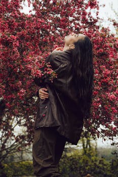 A woman in a leather jacket embraces nature surrounded by vibrant spring flowers in Istanbul.