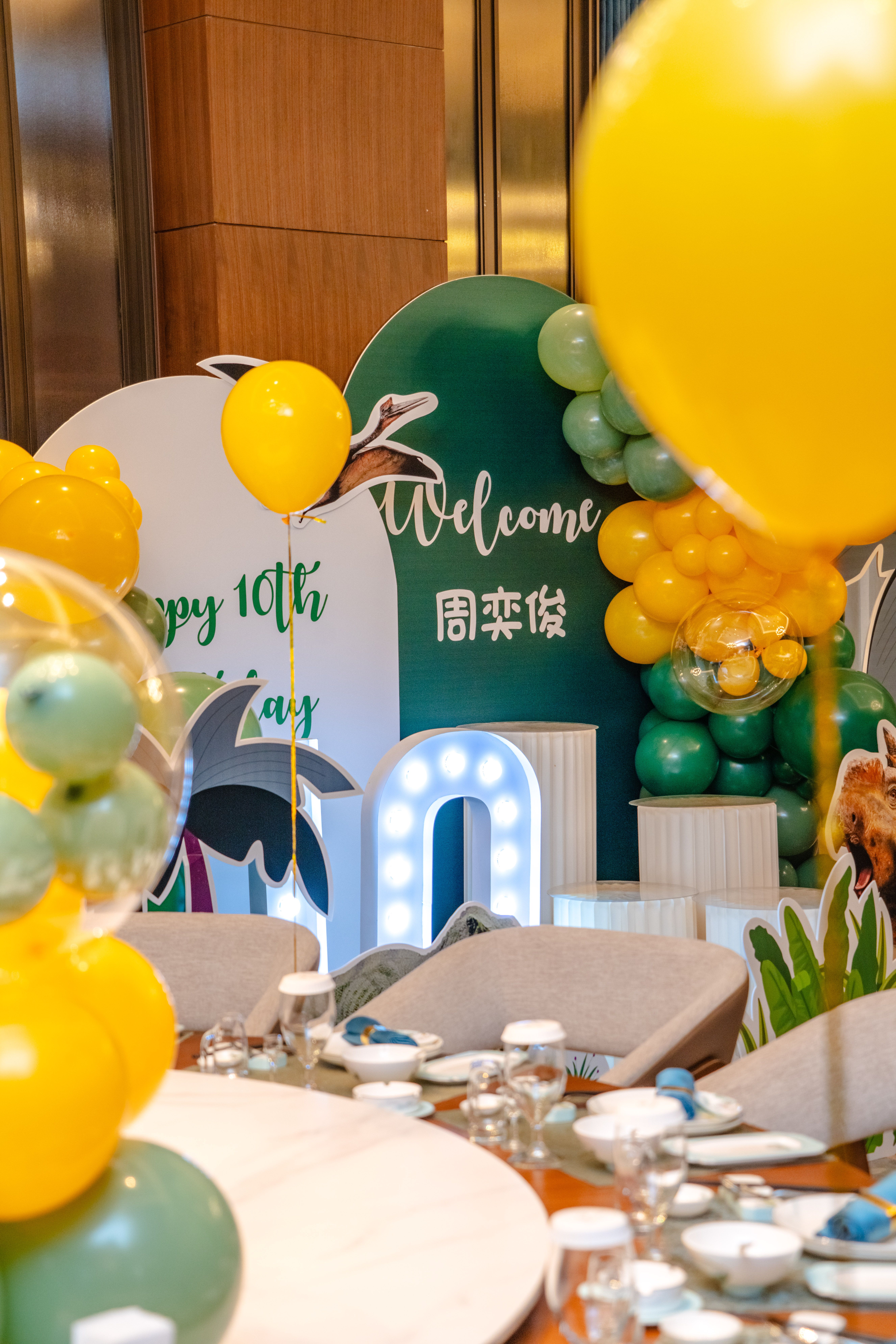 Birthday party hall decorated with a balloon arch and gift bags
