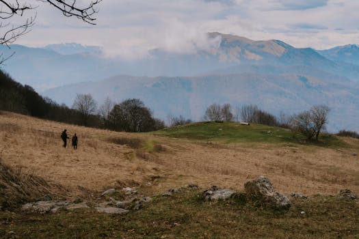 Two hikers explore the picturesque landscape of Canzo, Italy, with Alp views.