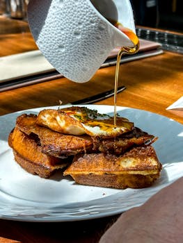 Close-up of a delicious brunch dish with crispy bread, fried egg, and syrup served in Atlanta.
