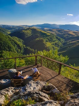 一对夫妇在木甲板上，欣赏着阿尔巴连绵起伏山丘的宁静景色