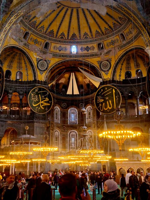 Free Bustling interior of Hagia Sophia with ornate details and visitors under grand chandeliers. Stock Photo