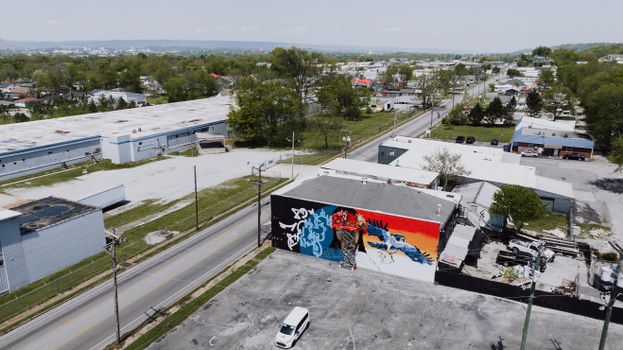 Aerial shot of a colorful mural in Chattanooga's industrial area on a sunny day.