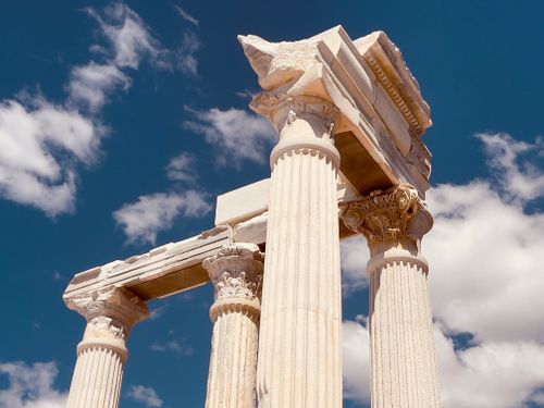 Free Elevated view of ancient Greek columns against a vibrant blue sky with clouds. Stock Photo