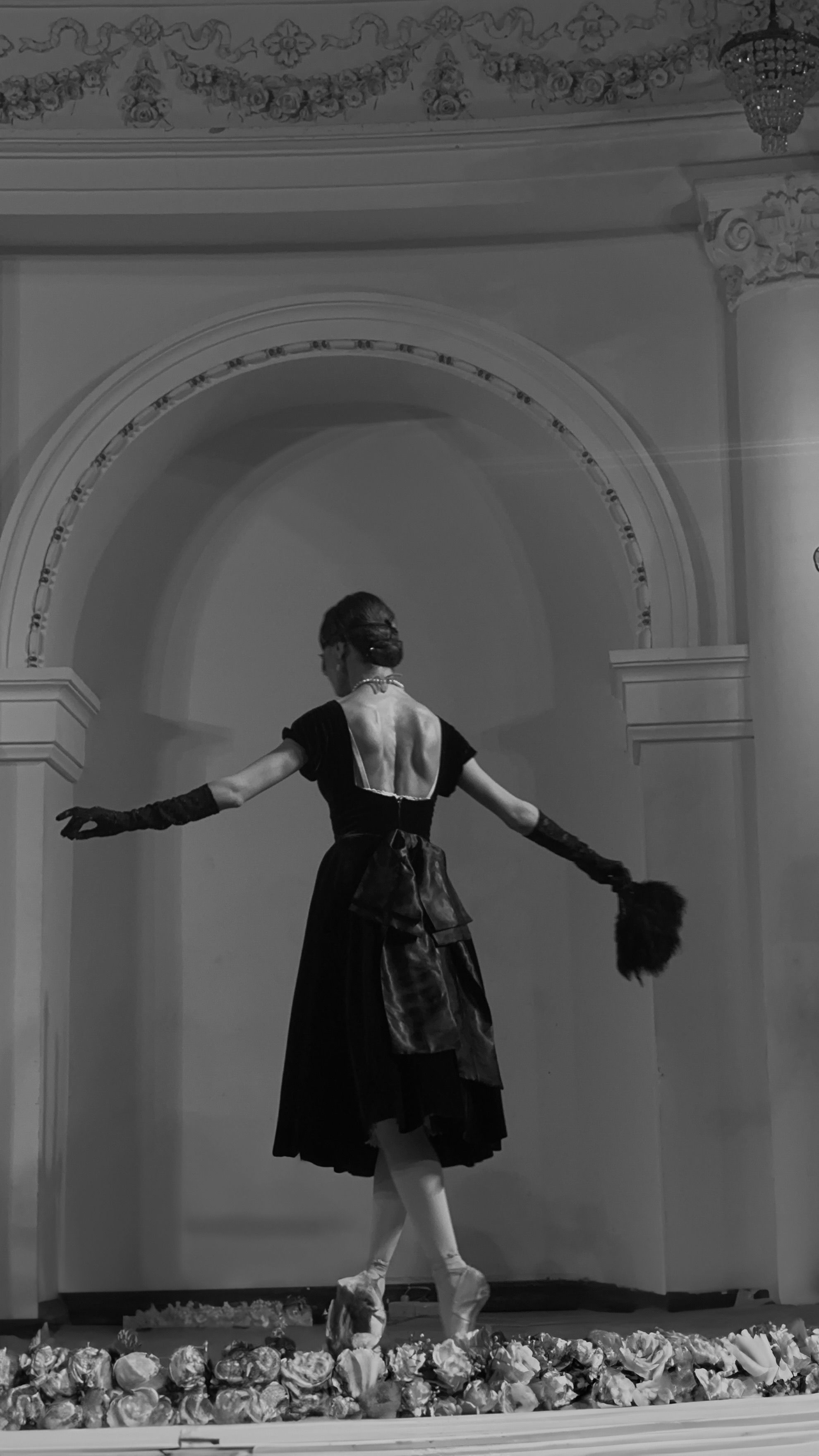 Graceful ballerina in a classic black dress performing on stage in Baku, Azerbaijan.
