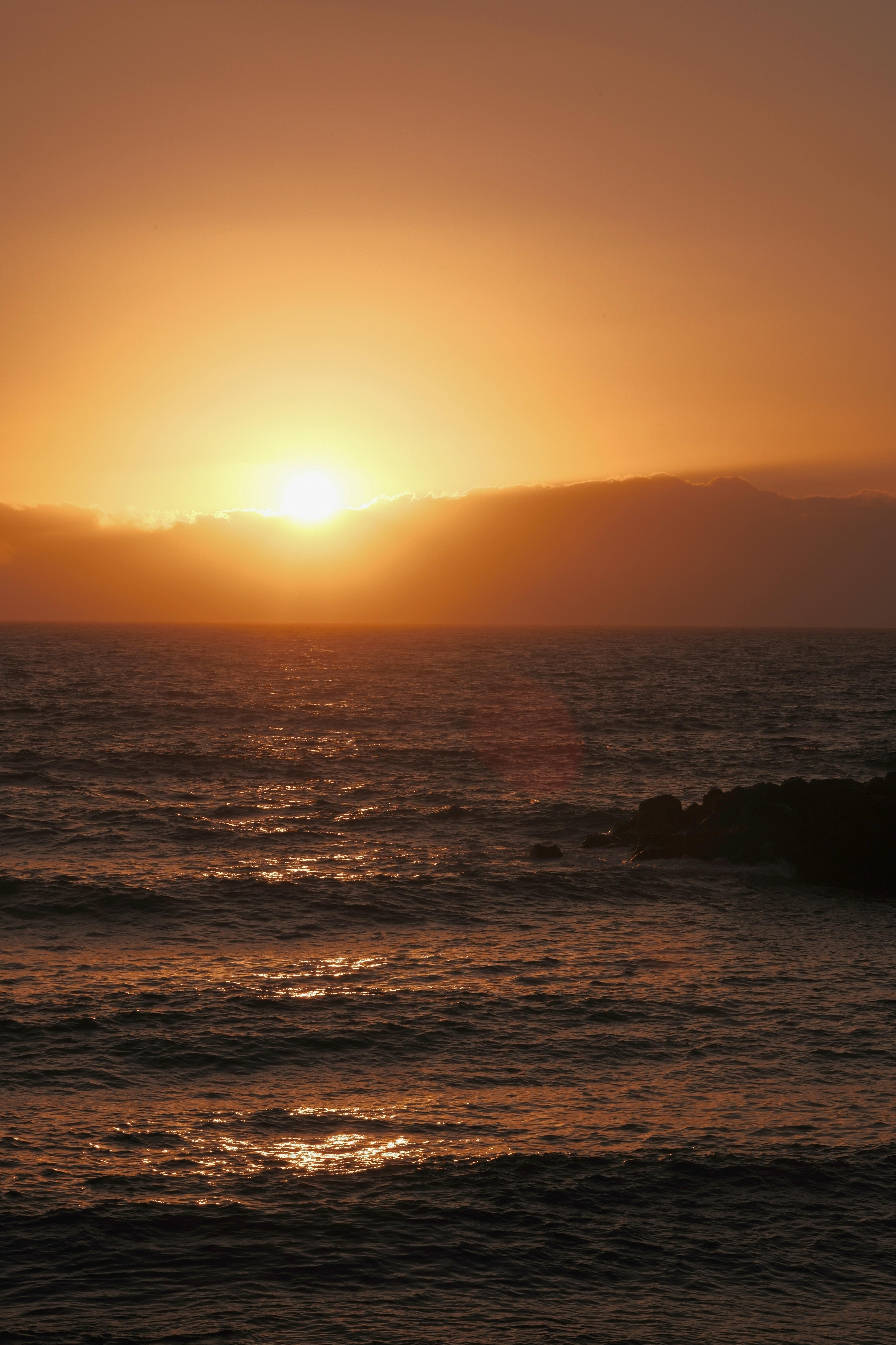Stunning view of a sunset over the ocean waves creating a serene atmosphere.