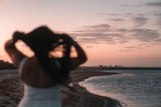 A silhouette of a woman at sunset on the peaceful shores of Corpus Christi, Texas.