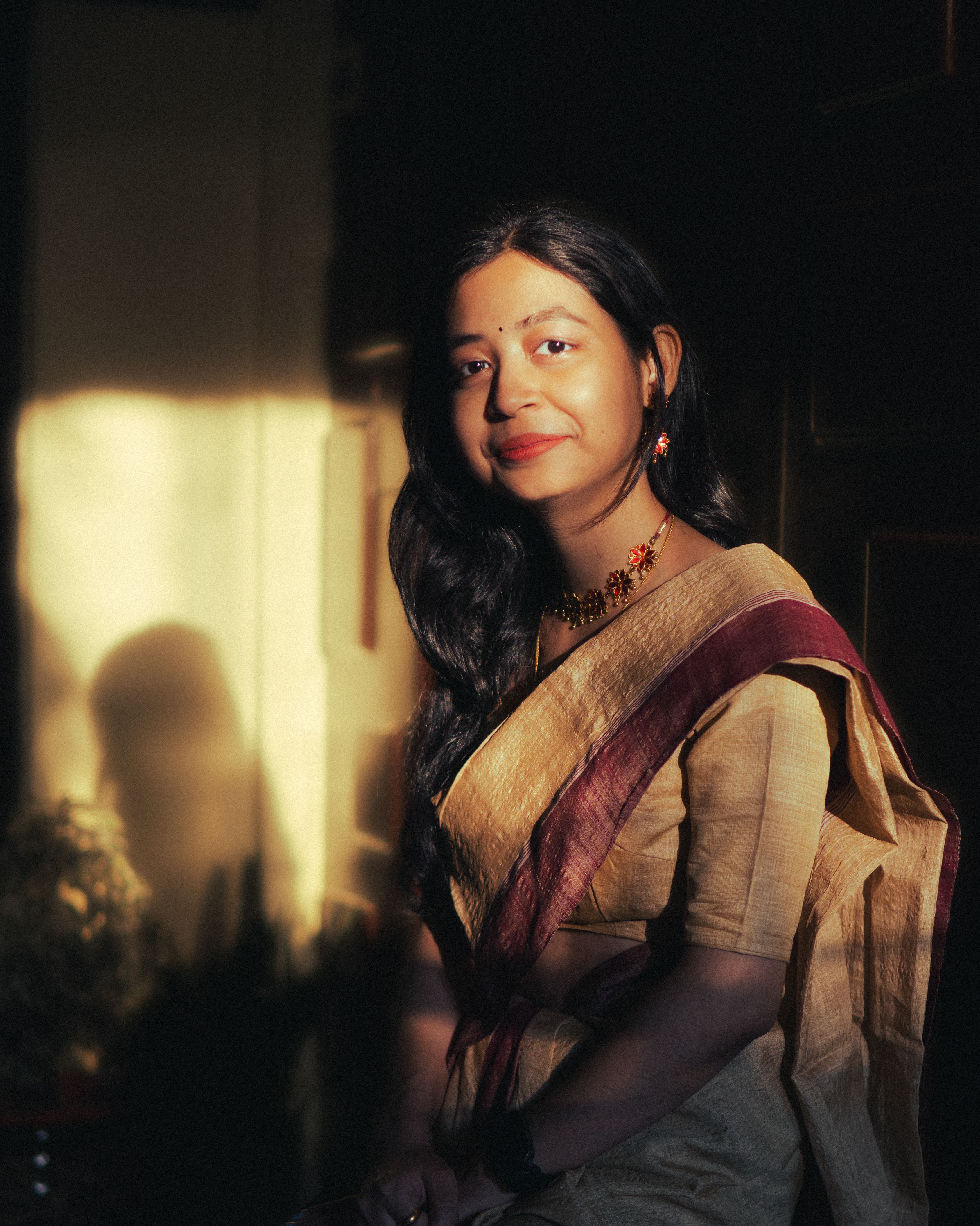 Portrait of an elegant woman in traditional Indian saree during golden hour.