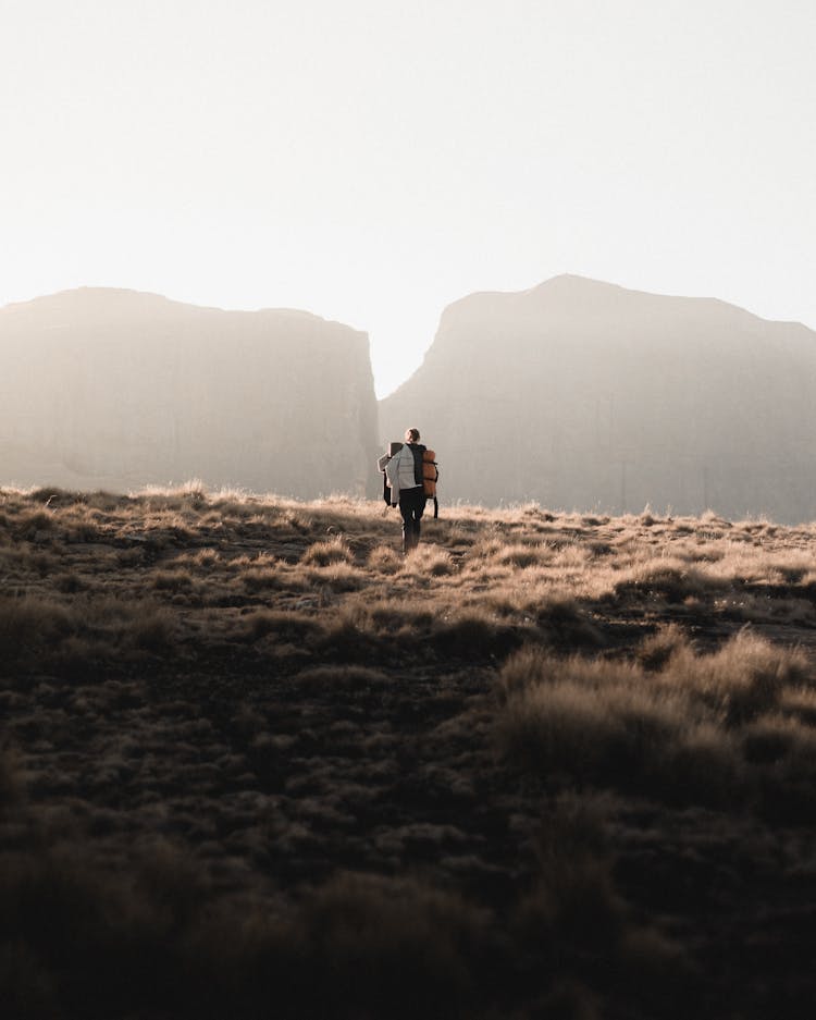 Person Walking On Grass Field